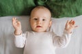 Portrait of a cute charming smiling laughing Caucasian white boy of six months old lying on a bed and looking at the camera. View Royalty Free Stock Photo