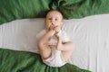 Portrait of a cute charming smiling laughing Caucasian white boy of six months old lying on a bed and looking at the camera. View Royalty Free Stock Photo