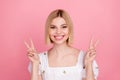Portrait of cute cheerful young lady smiling toothy showing v sign wear vintage sleeved shirt isolated pastel pink color Royalty Free Stock Photo