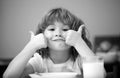 Portrait of cute child eating soup meal or breakfast having lunch by the table at home with spoon. Child nutrition. Kids