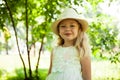 Portrait of cute child girl model in hat smiling in park or outdoor. Happy childhood, summer holidays and vacations Royalty Free Stock Photo