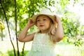 Portrait of cute child girl model in hat smiling in park or outdoor. Happy childhood, summer holidays and vacations Royalty Free Stock Photo