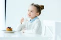portrait of cute child with glass of milk in hand and homemade pancakes with honey and berries Royalty Free Stock Photo