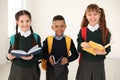 Portrait of cute children in school uniform with backpacks and books Royalty Free Stock Photo