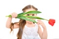 Portrait of cute curious girl looking through tulip