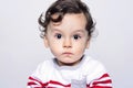 Portrait of a cute curly hair baby boy looking surprised. Royalty Free Stock Photo