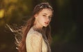 Portrait of a cute dreamy girl wearing retro blouse and skirt outdoors. Soft vintage toning.