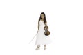 A portrait of a cute, elementary school Asian girl with long hair and wearing a white evening dress holding her violin Royalty Free Stock Photo