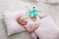 Portrait of cute european little blonde princess girl with bear in beautiful dress lying on the floor in decorated studio in Royalty Free Stock Photo