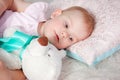 Portrait of cute european little blonde princess girl with bear in beautiful dress lying on the floor in decorated studio in Royalty Free Stock Photo