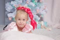 Portrait of cute european little blonde princess girl with crown in beautiful dress in decorated studio in christmas location with Royalty Free Stock Photo