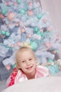 Portrait of cute european little blonde princess girl with crown in beautiful dress in decorated studio in christmas location with Royalty Free Stock Photo
