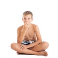 Portrait of a cute european teen boy wearing swimming shorts. A boy sitting on the floor.