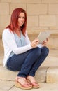 Portrait of a cute expressive redhead woman reading information on its touch pad Royalty Free Stock Photo