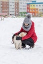 Portrait with cute fluffy puppy. Winter walk with dog. young woman walks with puppy, snowy winter Royalty Free Stock Photo
