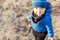 Portrait of cute funny caucasian toddler boy in blue jacket and hat enjoying walking at autumn park or forest during Royalty Free Stock Photo