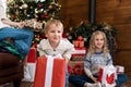 Portrait cute funny excited toddler baby boy with sister and mother open big white gift box christmas present against Royalty Free Stock Photo
