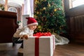 Portrait cute funny excited toddler baby boy wear santa red hat hold big white gift box christmas present against Royalty Free Stock Photo