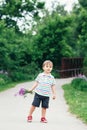 Portrait of a cute funny little boy toddler standing in the forest field meadow with dandelion flowers in hands Royalty Free Stock Photo