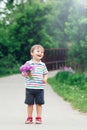 Portrait of a cute funny little boy toddler standing in the forest field meadow with dandelion flowers in hands Royalty Free Stock Photo