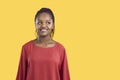 Portrait of cute and funny unsure african american woman biting her lip on yellow background.