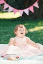 Portrait of cute funny upset sad crying Caucasian baby girl in pink tutu dress celebrating her first birthday Royalty Free Stock Photo