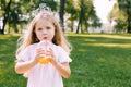 Portrait of cute girl with curly hair drinking orange juice in the park an looking at the camera Royalty Free Stock Photo