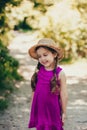 Portrait of cute girl dressed in bright standing in the forest road