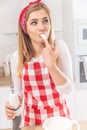 Portrait of a cute girl fingerlicking whisked egg whites with a hand whisk in the other hand Royalty Free Stock Photo