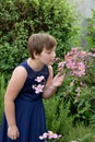 Girl smells of the blossoms of a Japanese anemone tomentosa