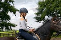 Portrait of cute girl  in helmet  horseback riding on brown horse Royalty Free Stock Photo