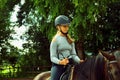 Portrait of cute girl in helmet horseback riding on brown horse Royalty Free Stock Photo