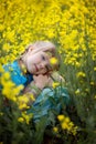 Portrait of a cute girl kid in a yellow rape flower field. A child in a blooming meadow. Authenticity, rural life, eco-friendly Royalty Free Stock Photo