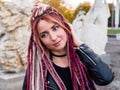 Portrait of cute girl with long pink dreadlocks, smiling and looking to the side Royalty Free Stock Photo