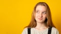 Portrait of a cute girl, looking positively to the side at the empty advertising space, smiling cute