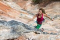 Portrait of Cute Girl rock Climber hanging on vertical orange wall Royalty Free Stock Photo