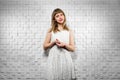 Portrait of cute girl in white dress in recording studio with a soundproof wall