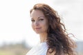 Woman in white sleeveless dress looks at camera Royalty Free Stock Photo