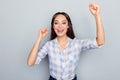 Portrait of cute, gorgeous, pretty, nice, happy woman celebrating a victory with raised arms over grey background Royalty Free Stock Photo