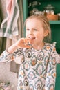 Portrait cute happy candid caucasian little kid girl five years old with blue eyes in beautiful dress with pattern animals have fu Royalty Free Stock Photo