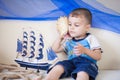 Portrait of Cute and happy caucasian little boy carefully listening to a big cockleshell