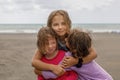 Portrait of cute happy kids playing together on the beach. Little girls hugging outdoors Royalty Free Stock Photo