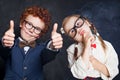 Portrait of cute happy kids in school uniform. Little boy and girl holding thumb up, thinking and smiling Royalty Free Stock Photo