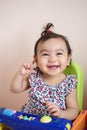 Portrait of cute happy little Asian baby girl wearing colorful shirt who recently had baby tooth laughing and look out, baby Royalty Free Stock Photo