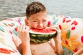 Cute happy little boy having fun in rubber ring eating juicy watermelon Royalty Free Stock Photo