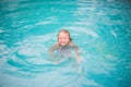 Portrait of cute happy little girl having fun in swimming pool. Kids sport on family summer vacation. Active healthy holiday Royalty Free Stock Photo