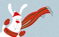Portrait of cute happy smiling white bunny or hare wearing Santa claus red hat, mittens and scarf on snowing christmas