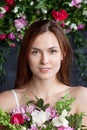 Portrait of a cute happy woman holding flowers over dark  background. Looking at camera. Skin care concept.  Beautiful woman with Royalty Free Stock Photo