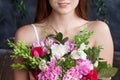 Portrait of a cute happy woman holding flowers over dark  background. Looking at camera. Skin care concept.  Beautiful woman with Royalty Free Stock Photo