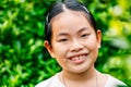 Portrait of cute and healthy Asian child girl in 8 to 9 years old, close up to face, smiling, looking at camera, outdoor image, Royalty Free Stock Photo